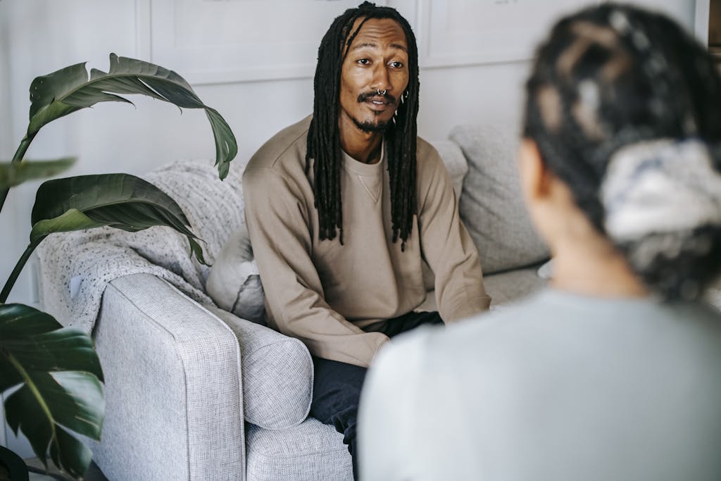 A calm discussion between two adults on a comfortable sofa indoors.